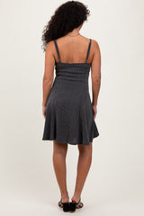 woman wearing a black and white striped sleeveless dress with a flared skirt, viewed from the back