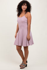 woman wearing a light purple striped sleeveless dress with a flared skirt and black heeled sandals