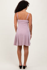woman wearing a lilac striped sundress with a flared skirt and spaghetti straps, viewed from the back