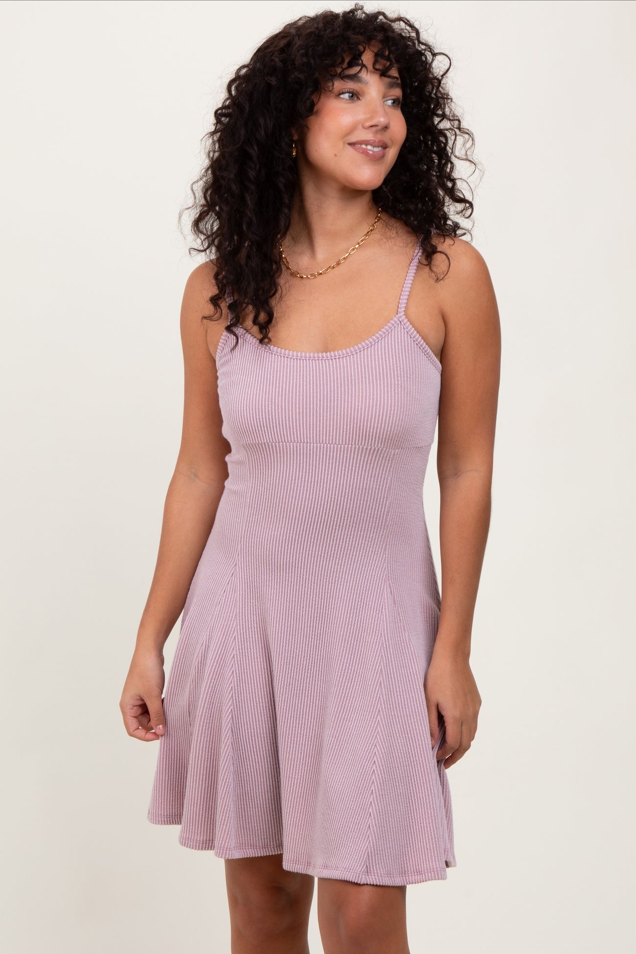 woman wearing a light pink ribbed spaghetti strap dress with a flared skirt