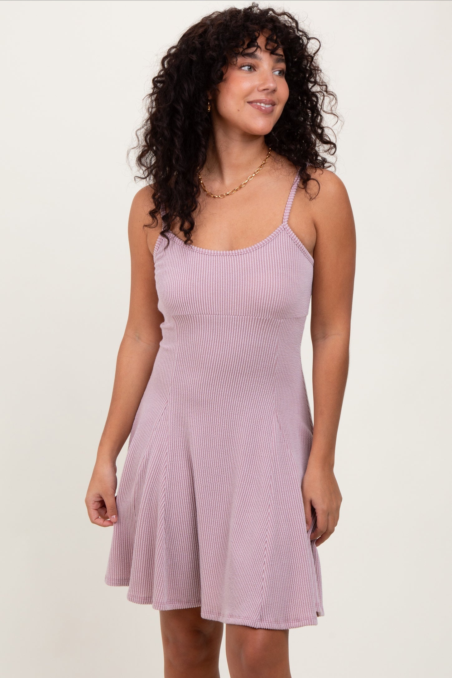 woman wearing a light pink ribbed spaghetti strap dress with a flared skirt