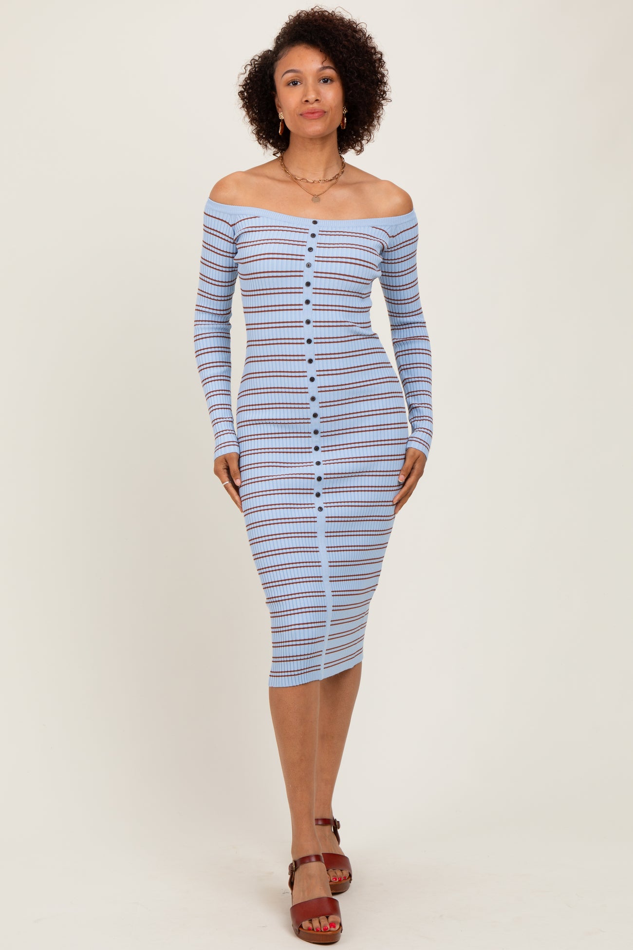 woman wearing a blue and white striped off-shoulder midi dress with a button-up front and long sleeves
