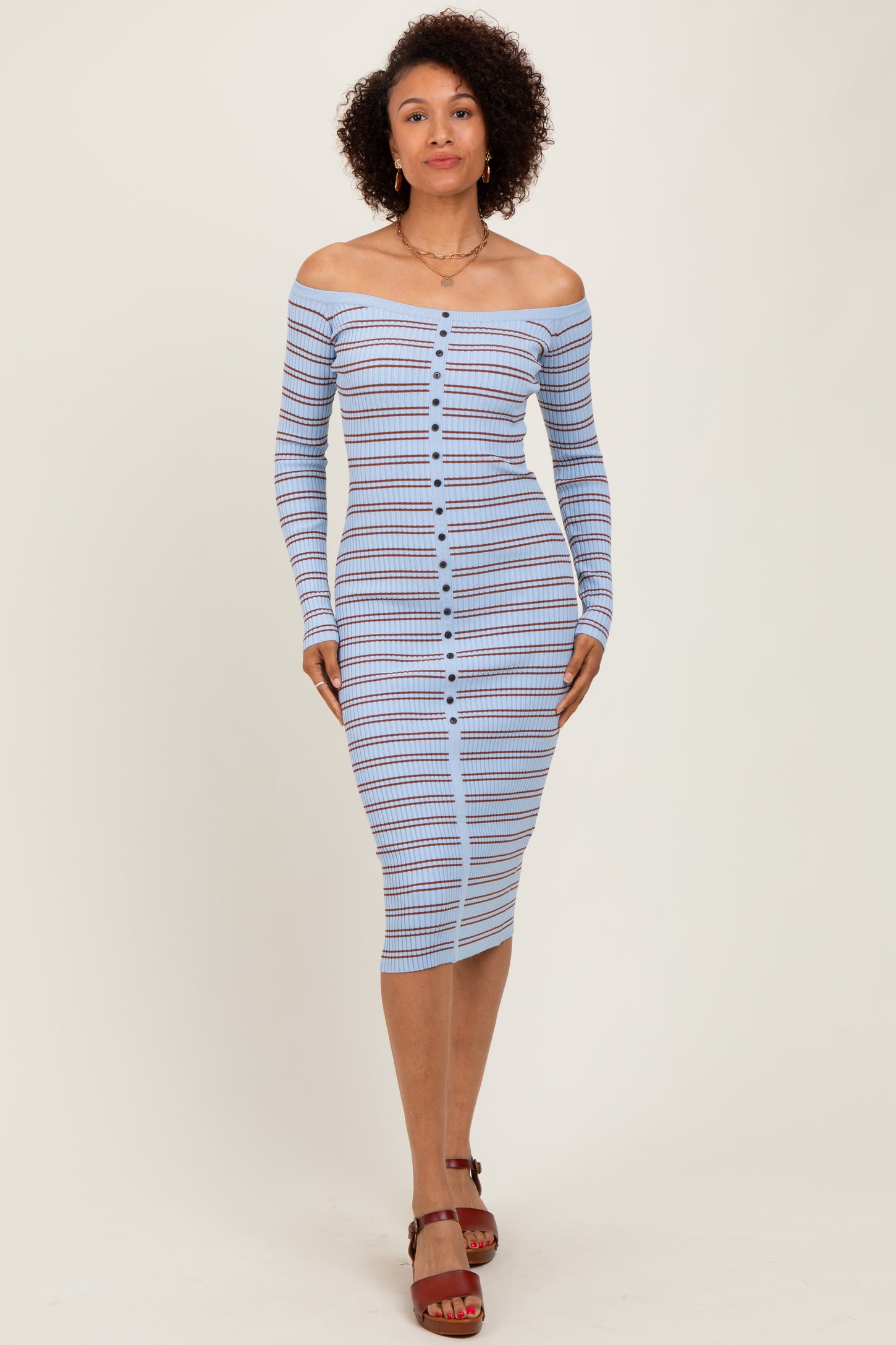 woman wearing a blue and white striped off-shoulder midi dress with a button-up front and long sleeves