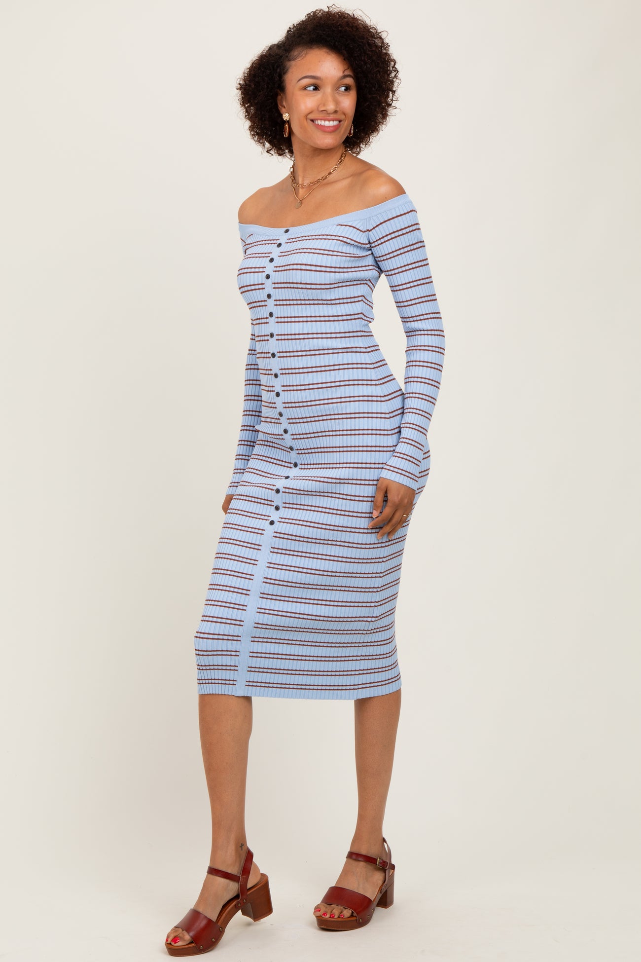 woman wearing a light blue off-shoulder striped midi dress with button details and sandals