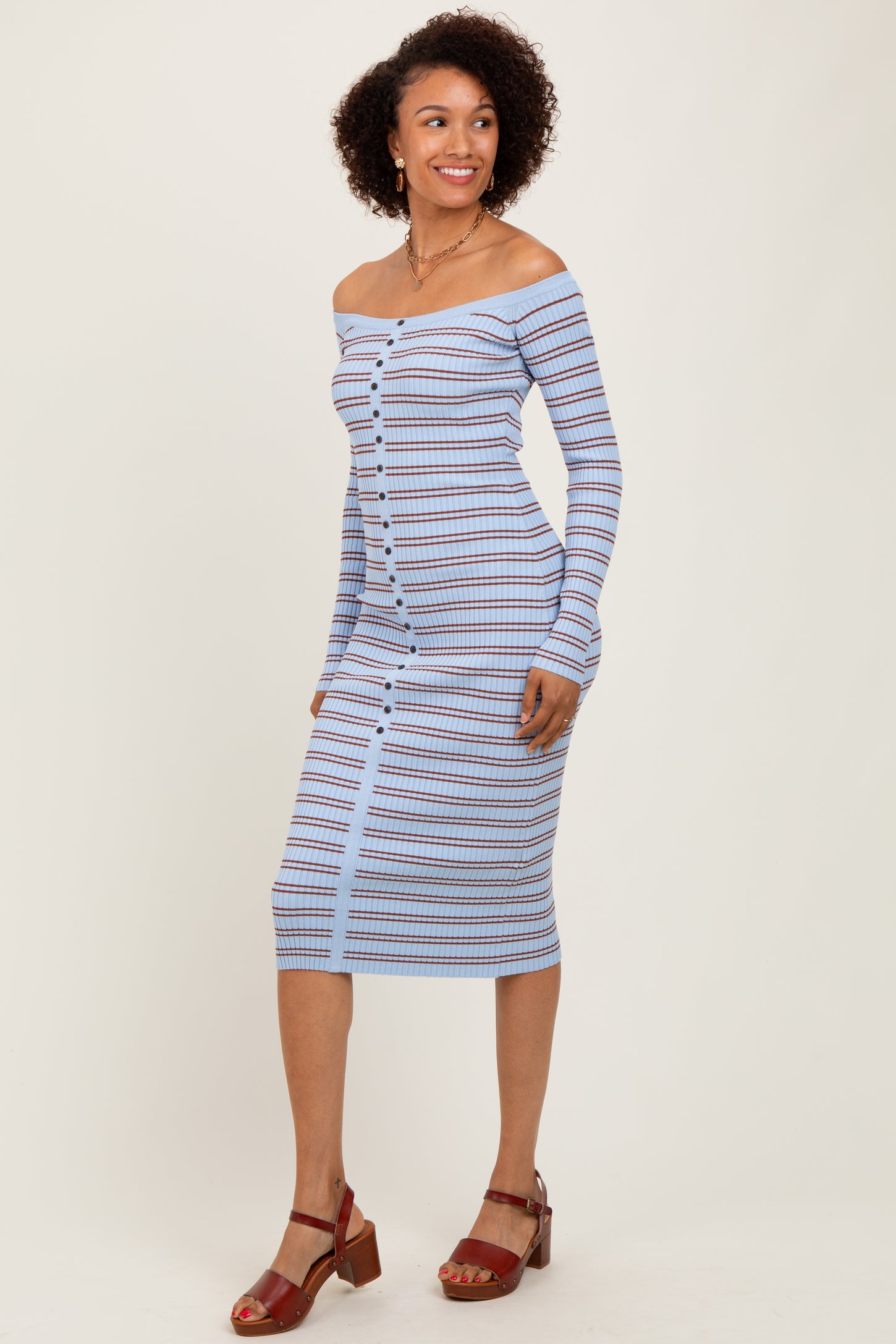 woman wearing a light blue off-shoulder striped midi dress with button details and sandals