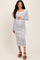 woman wearing a white and navy striped maternity dress with buttons, highlighting her baby bump
