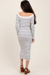 woman wearing a white and navy striped long sleeve maternity dress, showing her baby bump from the back