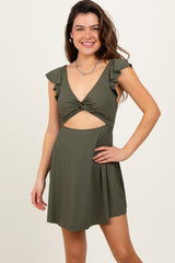 woman wearing an olive green ruffled short dress with a cut-out design and twist front detail