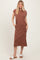 woman wearing a rust-colored sleeveless maxi dress with side pockets and a relaxed fit
