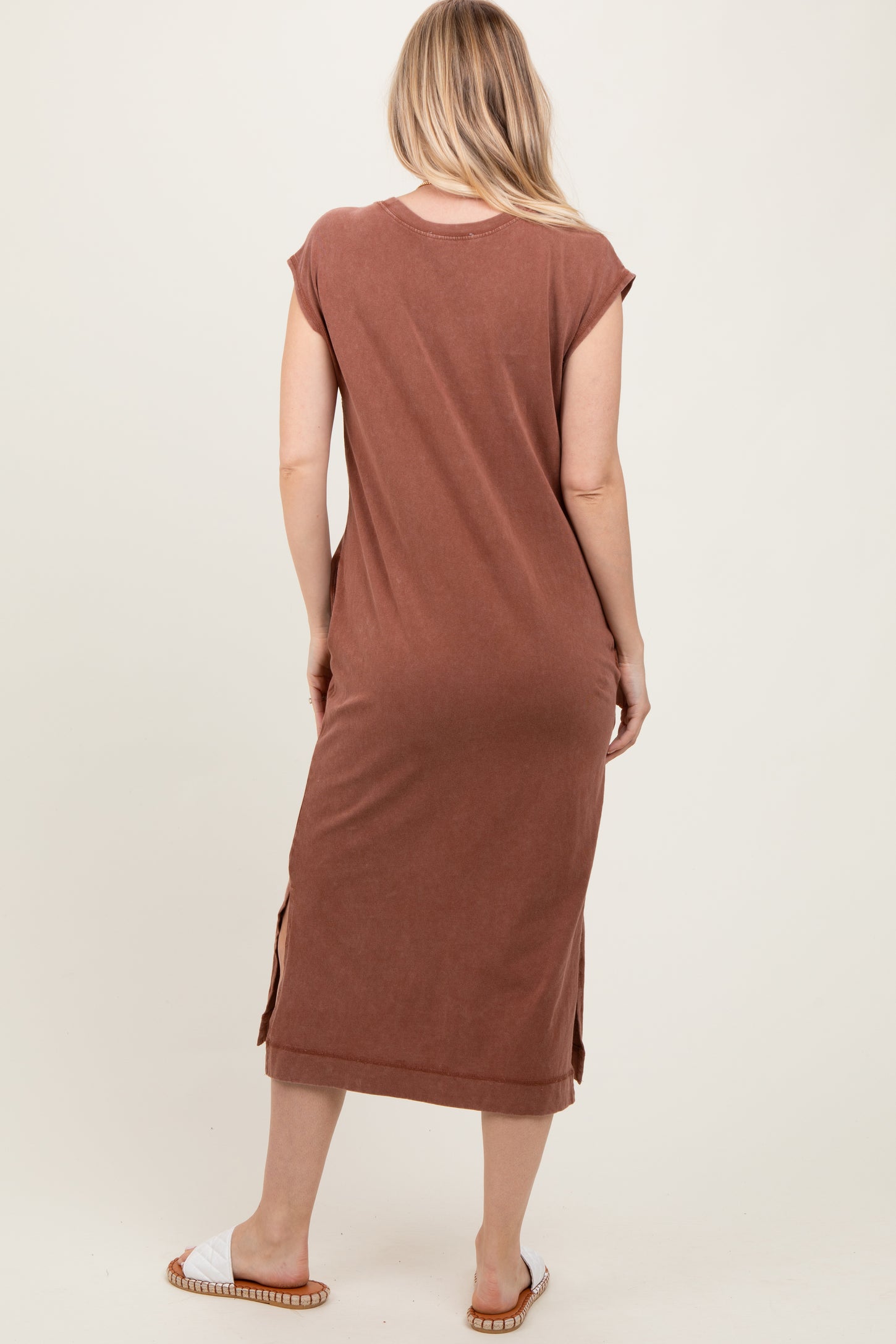 woman wearing a brown midi dress with cap sleeves and side slits, shown from the back