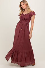 woman wearing a burgundy maxi dress with flutter sleeves and button details, posing gracefully