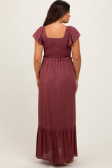 woman wearing a burgundy maternity maxi dress with a smocked bodice and flutter sleeves, viewed from the back