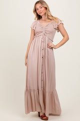 woman wearing a light pink maxi dress with ruffled sleeves and a button-down front
