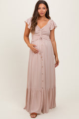 woman wearing a dusty pink maternity maxi dress with flutter sleeves and a cinched bodice, showcasing her baby bump