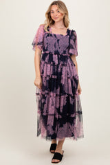 woman wearing a navy and pink floral tiered maxi dress with short sheer sleeves and a square neckline