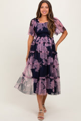 woman wearing a navy blue floral printed tiered maternity dress with short sleeves, showcasing a baby bump