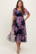 woman wearing a navy blue floral printed tiered maternity dress with short sleeves, showcasing a baby bump
