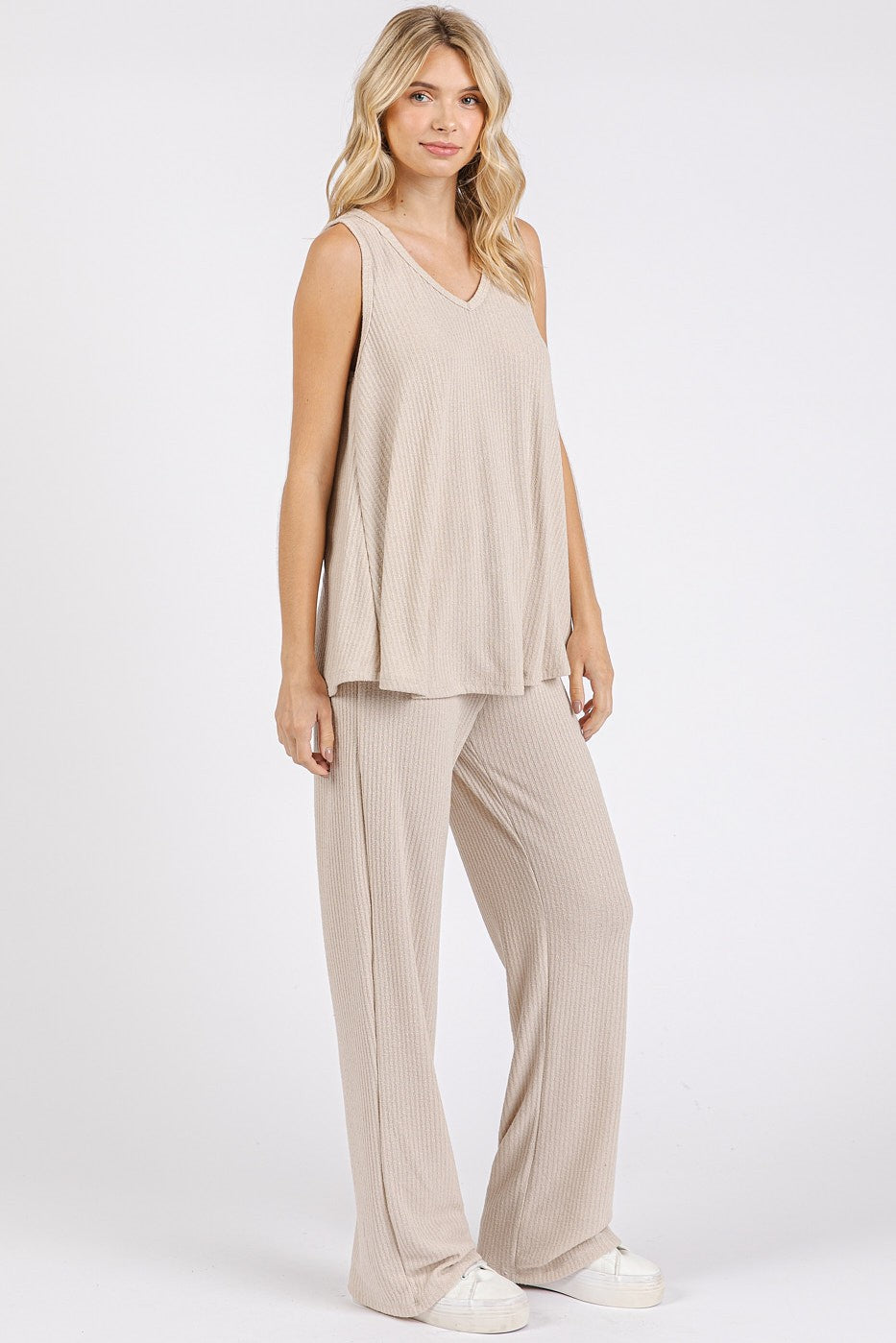 woman wearing a beige sleeveless v-neck top and matching wide-leg pants in a relaxed fit