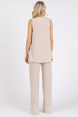 woman wearing a beige sleeveless knit top and matching wide-leg pants, shown from the back