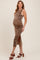 woman wearing a leopard print maternity dress with a side slit, showcasing her baby bump and paired with brown heeled sandals