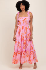 woman wearing a pink floral maxi dress with ruffled straps and a tiered skirt