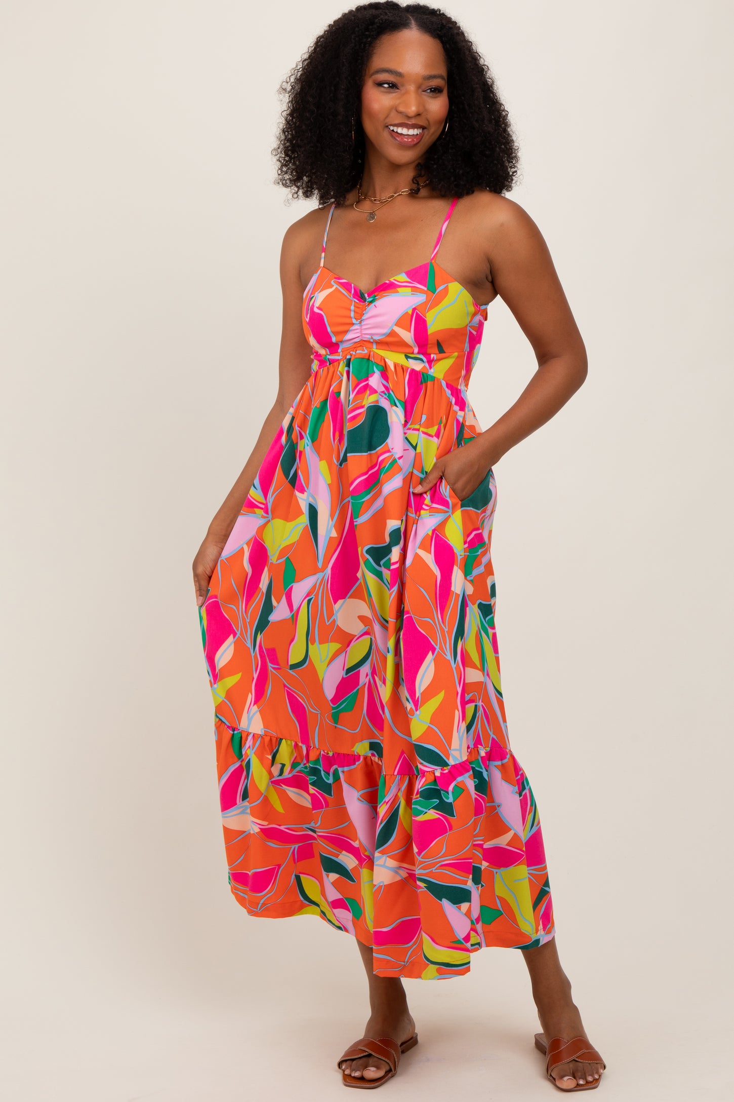 woman wearing a vibrant multicolored floral maxi dress with spaghetti straps and pockets