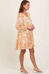 woman wearing a floral printed short dress with puff sleeves and a v-neckline, standing in profile