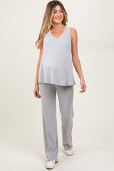 woman wearing a light gray ribbed maternity top and matching pants, showing her baby bump