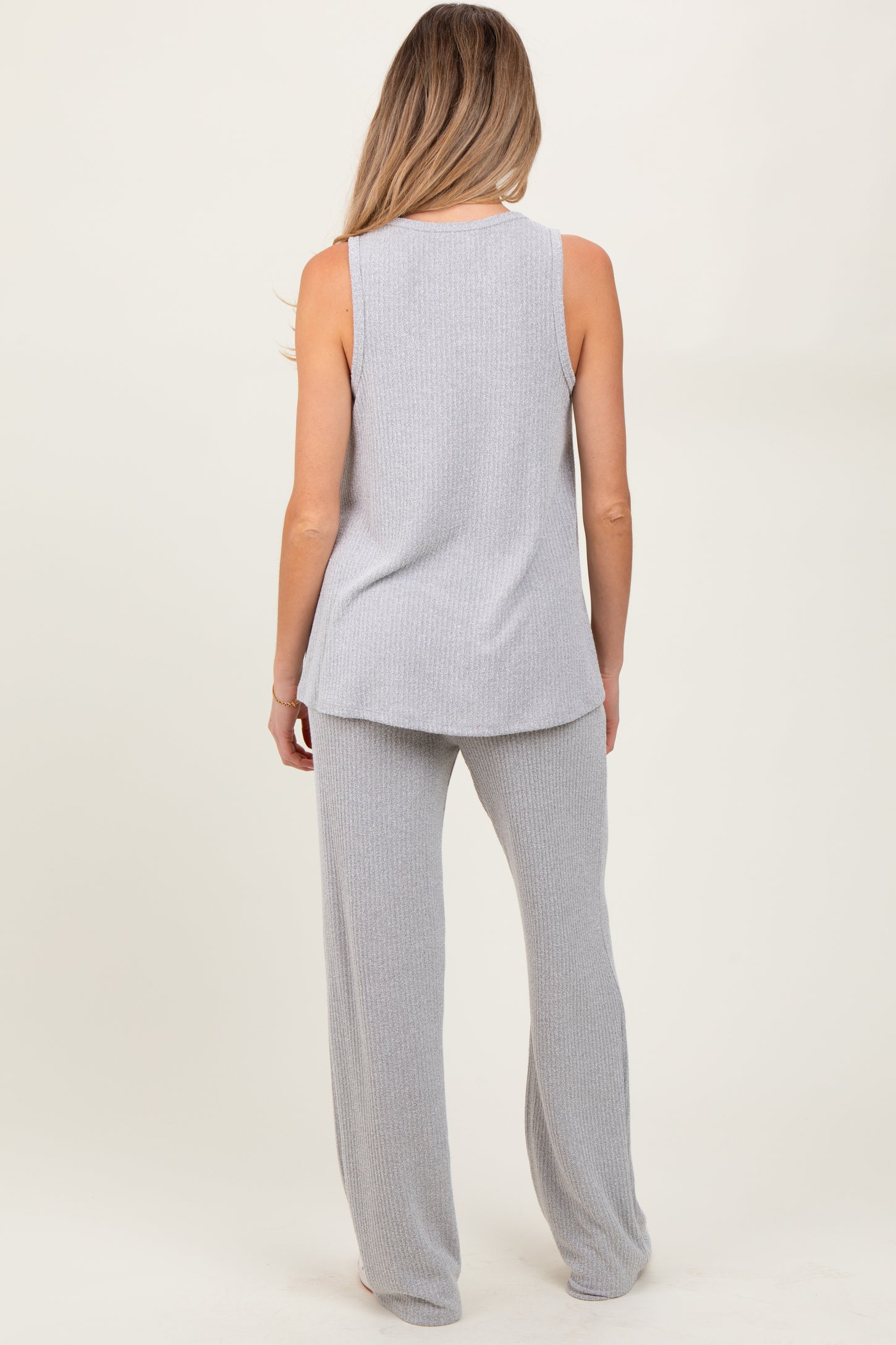 woman wearing a light gray maternity ribbed tank top and matching wide-leg pants, viewed from the back