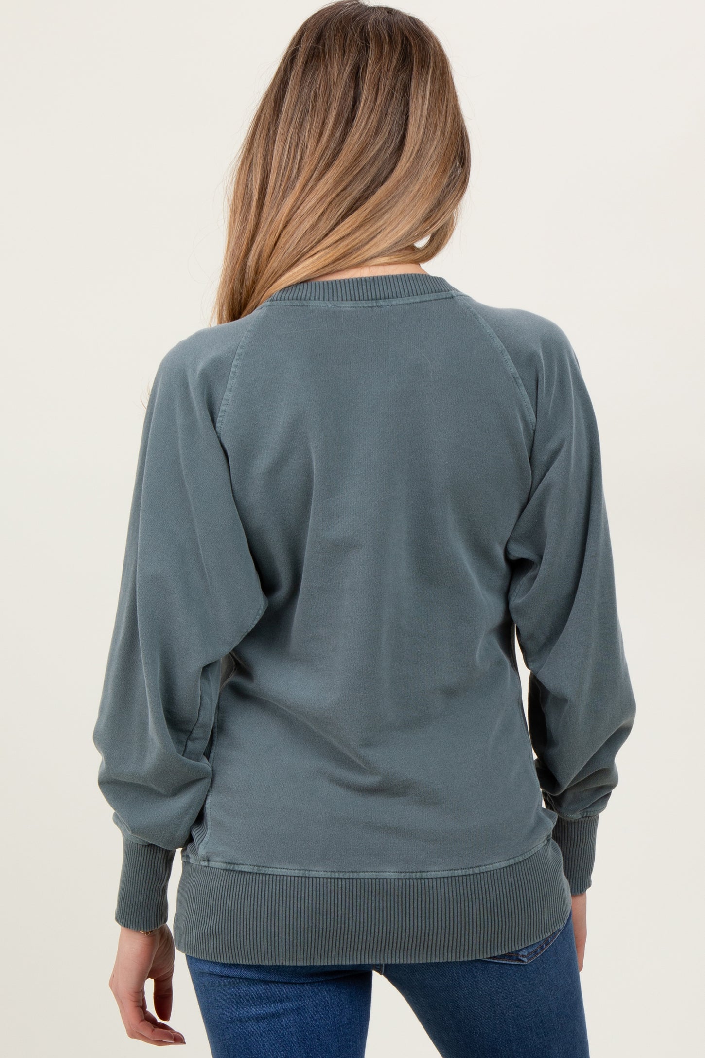woman wearing a maternity sweatshirt in dark teal, featuring a relaxed fit and ribbed trim, shown from the back