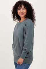 woman wearing a dusty blue oversized sweatshirt with ribbed cuffs and hem, styled casually with jeans