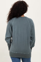 woman wearing a dark teal relaxed fit sweatshirt with a ribbed hem and cuffs, viewed from the back