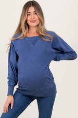 woman wearing a dark blue maternity sweatshirt with a relaxed fit and gathered sides, showcasing her baby bump