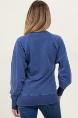 woman wearing a blue maternity sweatshirt with long sleeves, shown from the back