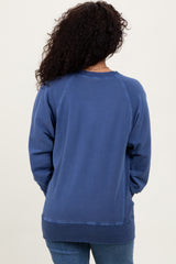 woman wearing a blue oversized sweatshirt, seen from the back, with a relaxed fit and ribbed hem