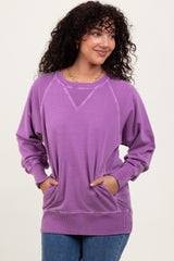 woman wearing a purple long sleeve sweatshirt with side pockets and a relaxed fit