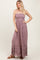 woman wearing a mauve strapless maxi dress with smocking and ruffled hem