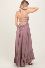 woman wearing a lavender halter neck maxi dress with a tiered ruffle hem and strappy back details