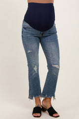 woman wearing blue distressed maternity jeans with a navy belly panel and frayed hem, showing her baby bump