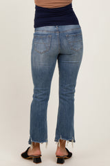 woman wearing a pair of light blue maternity jeans with a frayed hem and a fitted waistband, showing a baby bump