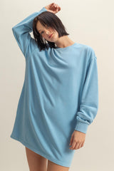 woman wearing a light blue oversized sweatshirt dress with long sleeves and a relaxed fit