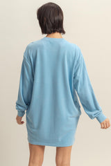 woman wearing a relaxed fit light blue sweatshirt dress with long sleeves