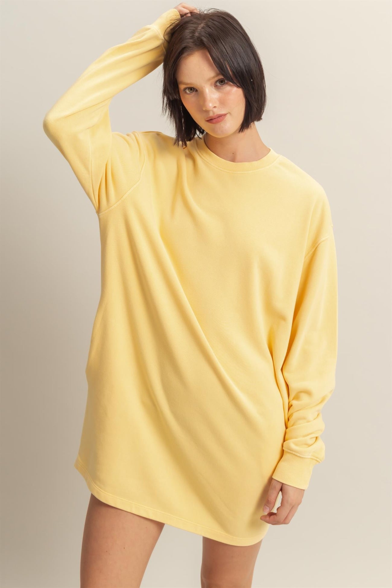 woman wearing a yellow oversized long sleeve sweatshirt dress