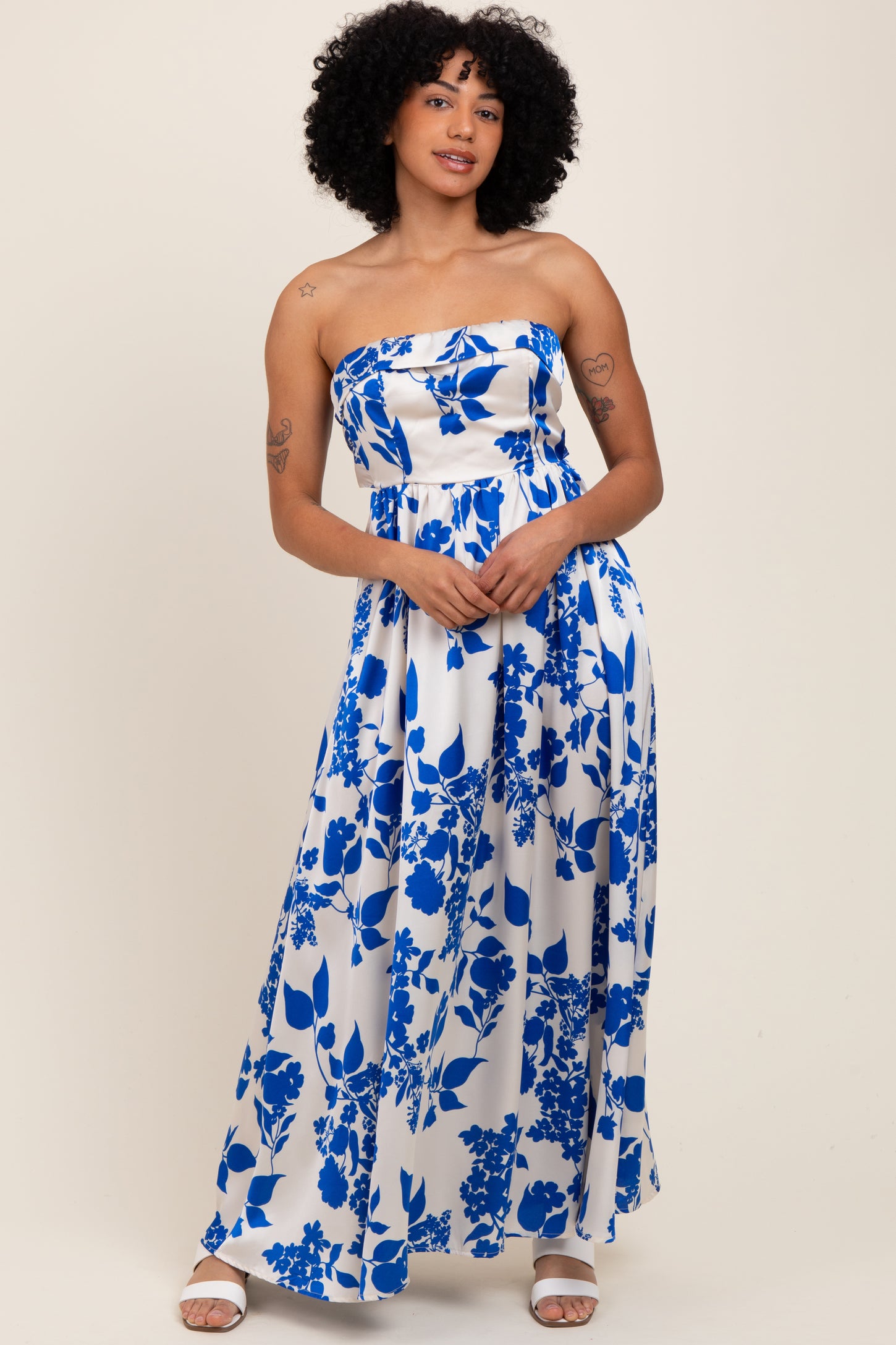 woman wearing a strapless maxi dress with a blue floral print on a white background