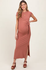 woman wearing a dusty rose maternity maxi dress with a twist detail and side slit, showing her baby bump