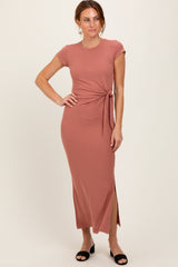 woman wearing a dusty rose short sleeve maxi dress with a side tie detail and a thigh-high slit