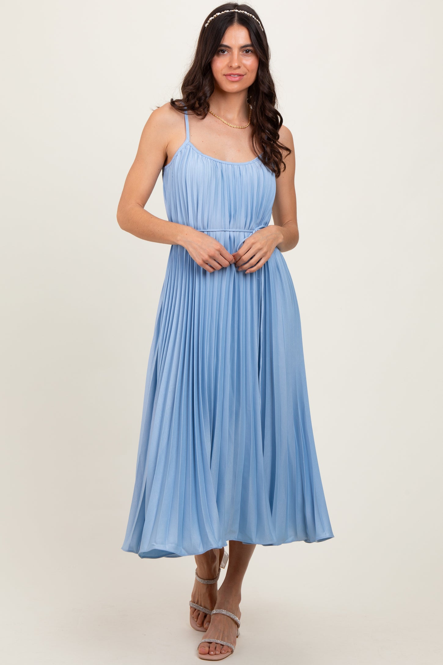 woman wearing a light blue pleated midi dress with spaghetti straps and a fitted bodice
