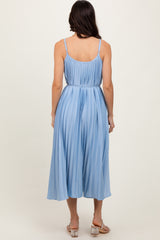 woman wearing a light blue pleated midi dress with adjustable spaghetti straps and a fitted waist, viewed from the back