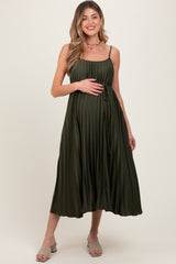 woman wearing a dark green midi maternity dress with a tie waist, holding her baby bump