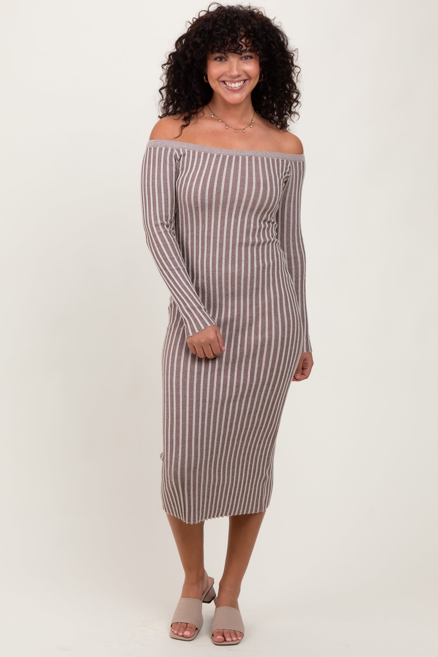 woman wearing a brown and white striped off-the-shoulder midi dress with long sleeves and side button details